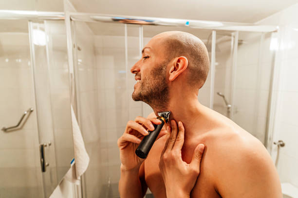 istock Young man trimming his beard with a trimmer 1494343790