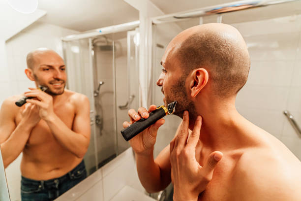 istock Young man trimming his beard with a trimmer 1494343833