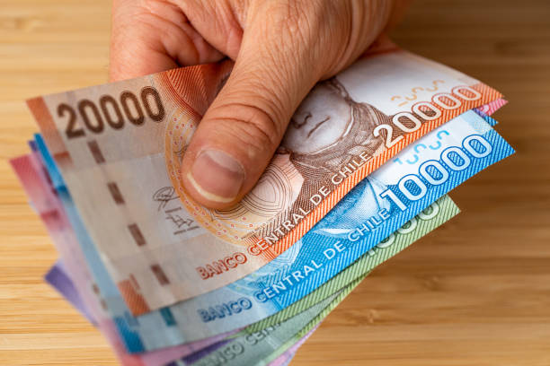Chile money, A stack of pesos banknotes being fed, Financial and economic concept Chile money, A stack of pesos banknotes being fed, Financial and economic concept, close up chile stock pictures, royalty-free photos & images