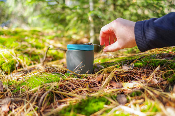 手がマグカップに手を伸ばします。森の中の自然の中のマグカップ。森の中の晴れた日。 - heliac ストックフォトと画像