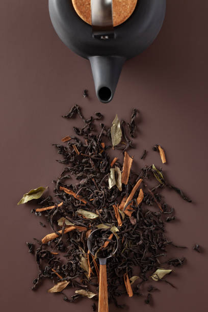 Tea leaves and teapot on a brown background
