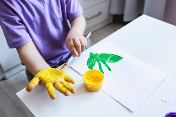 istock Children's art workshop, the child makes a handprint with paints 1494350804