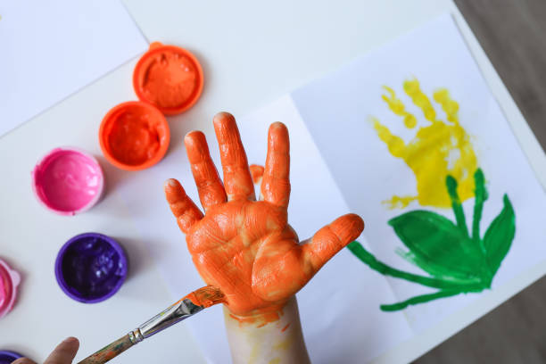 istock Children's art workshop, the child makes a handprint with paints 1494350834