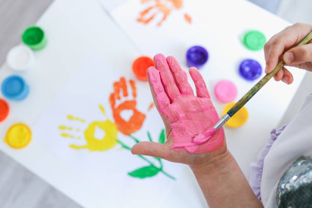 istock Children's art workshop, the child makes a handprint with paints 1494350835