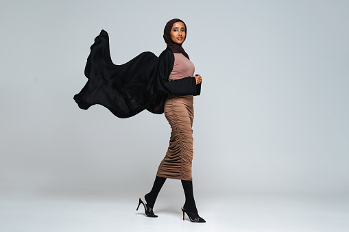 Beautiful arab middle-eastern woman with traditional abaya dress in studio - Black african muslim adult female wearing fashionable and stylish arabic dress portrait in Dubai, United Arab Emirates