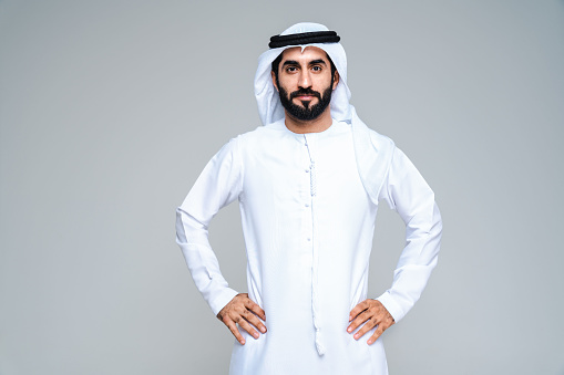 Handsome arab middle-eastern man with traditional kandora in studio - Arabic muslim adult male portrait wearing emirate clothing in Dubai, United Arab Emirates