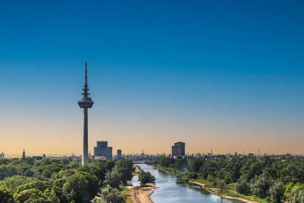 View to the Fernmeldeturm and river Neckar in Mannheim, Germany. Television TV telecommunications tower. Beautiful evening light. Copy space.