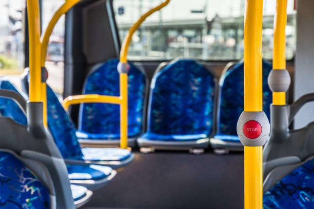 istock Stop button on the modern public transport bus. Empty bus interior. Public transport in the city. Passenger transportation. Bus with blue seats and yellow handrails. 1494356932