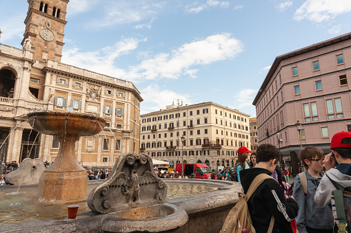 Genoa, Italy - May 18, 2017: Tourists and locals are walking on Piazza Banchi in Historic Center of Genoa, Italy. This photograph was taken midday with full frame camera and Zeiss wide-angle lens.