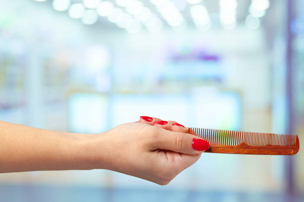 istock Female hand holding barber comb in cosmetic store 1494361402