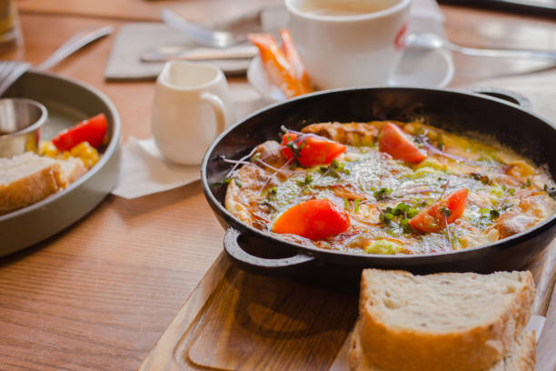 istock Fried eggs with tomato and ham in pan. Served breakfast table. Omelette with tomato and bread. Spanish tortilla. Eggs with pesto and vegetables. Ready to eat food. 1494362697