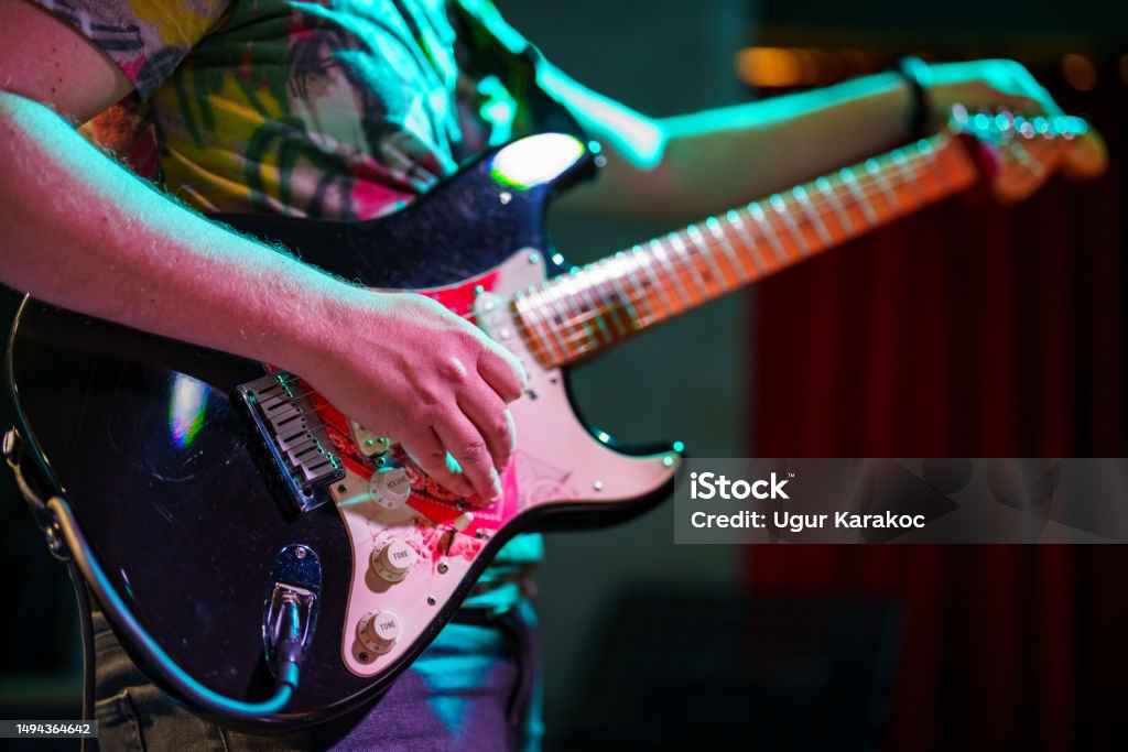 Musicians tuning the guitar on stage Musicians on stage performing Music Style Stock Photo