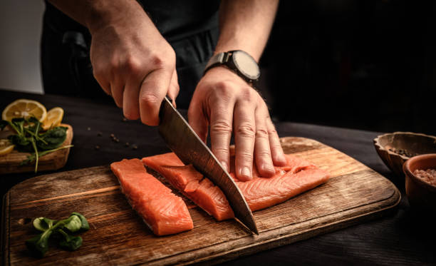 istock chief cutting a salmon fillet into pieces for cooking 1494365864