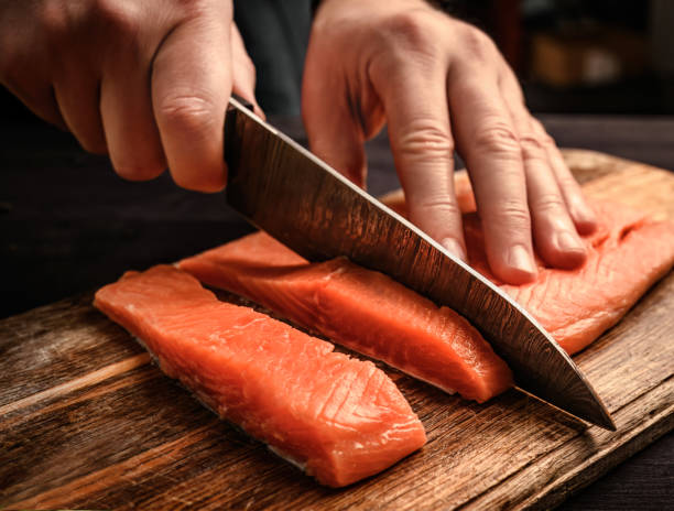 istock chief cutting a salmon fillet into pieces for cooking 1494365879