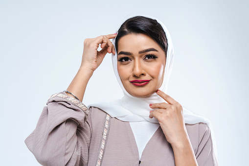 Beautiful arab middle-eastern woman with traditional abaya dress in studio - Arabic muslim adult female portrait in Dubai, United Arab Emirates