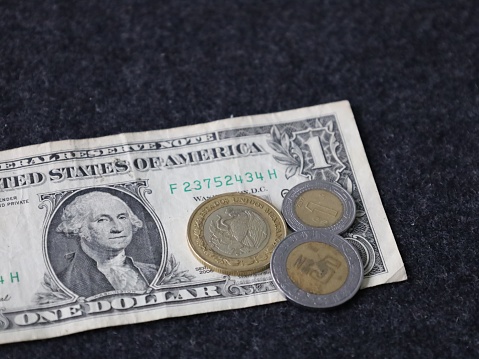 american one dollar bill and mexican coins of different denomination