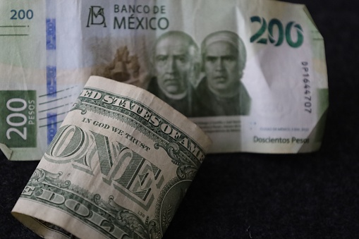 approach to rolled american bill and mexican banknote