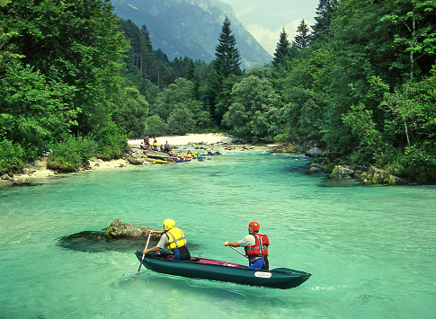 Inflatable canoe in river rapids - White water rafting on the rapids of river Soca in Triglav national park, Slovenia. Soca is one of the most beautiful rivers of Europe.