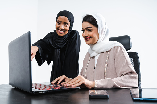 Beautiful arab middle-eastern women with traditional abaya dress in studio - Arabic muslim adult female businesswomen working together in the office in Dubai, United Arab Emirates