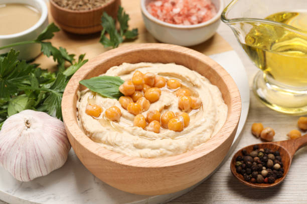 istock Delicious hummus with chickpeas and different ingredients on white wooden table, closeup 1494368669