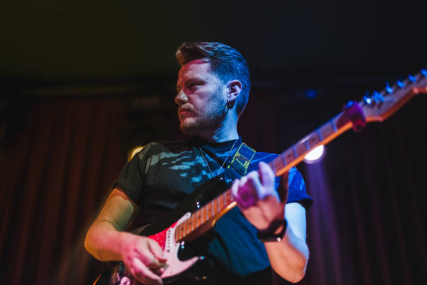 istock Musicians playing electric guitar and singing on stage 1494369906