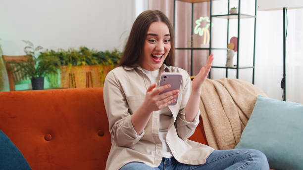 istock Happy young woman at home use smartphone typing browsing wow yes found out great big win celebrate 1494370458