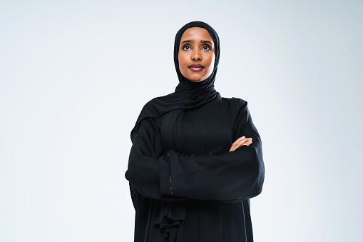 Beautiful arab middle-eastern woman with traditional abaya dress in studio - Arabic muslim adult female portrait in Dubai, United Arab Emirates