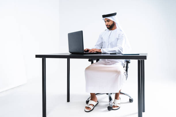 Emirate middle-eastern businessman wearing kandora working in the office, Dubai