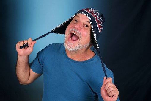 happy bald man with white beard Peruvian cap on his head looking forward with good expression