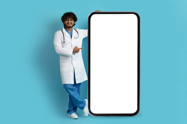 istock Cheerful indian doctor pointing at huge cell phone, mockup 1494372090