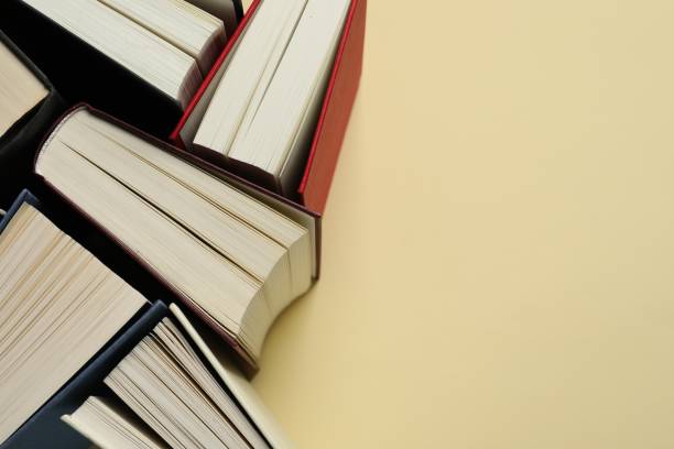 istock Many hardcover books on light yellow background, closeup. Space for text 1494372092