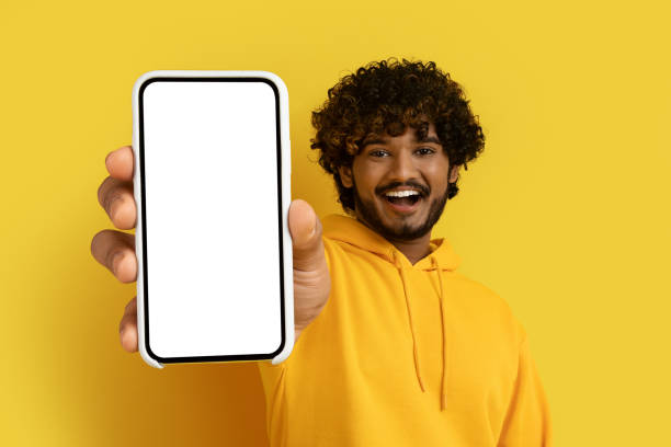 istock Positive young indian man showing huge smartphone, mockup 1494372099