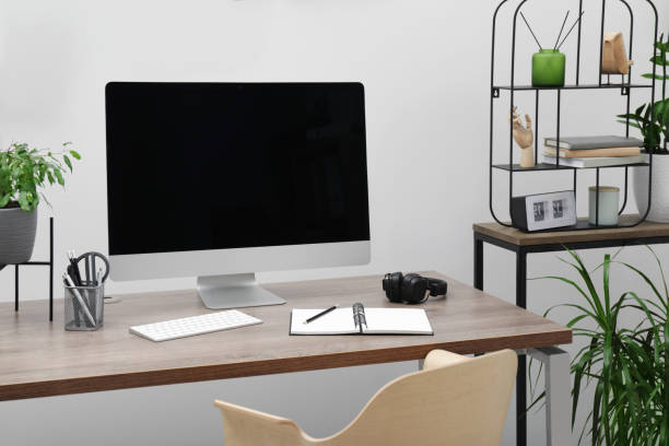 istock Cozy workspace with computer on desk near white wall at home 1494372370