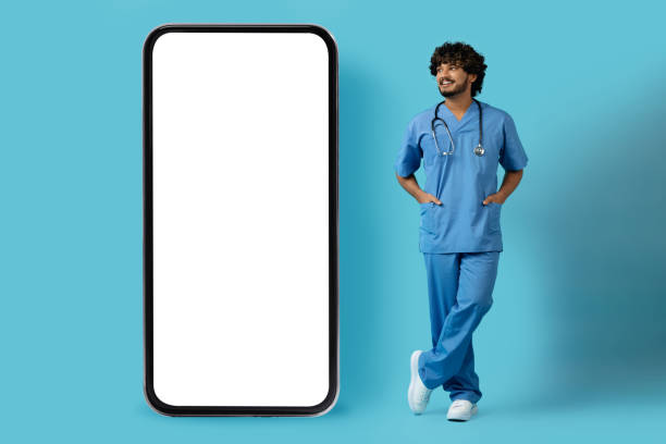 istock Cheerful indian doctor surgeon pointing at huge cell phone, mockup 1494372661