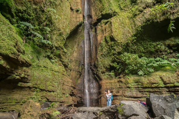 Women at Ribeira Quente waterfall, Azores One women at Ribeira Quente Waterfall on São Miguel, the Azores madalena stock pictures, royalty-free photos & images