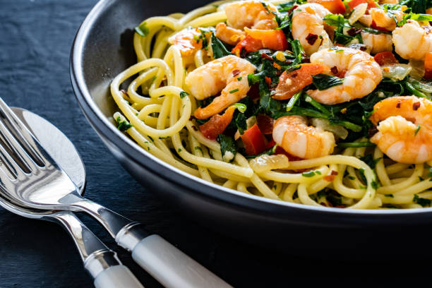 istock Spaghetti with prawns and stir-fried vegetables on black background 1494377286