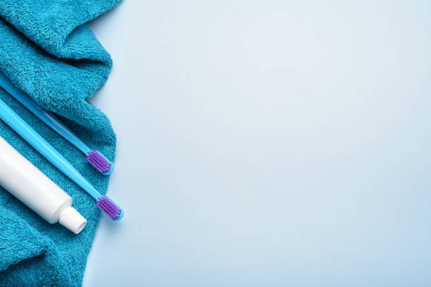 istock Toothbrushes with paste tube on blue terry towel. Top view, copy space. 1494379923