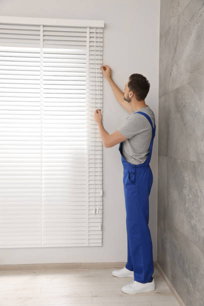 istock Worker in uniform opening or closing horizontal window blind indoors 1494379929
