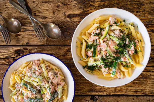 istock Pasta with salmon and vegetables on wooden table 1494379991