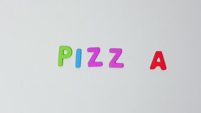 The word pizza is made of moving colored wooden letters. Pizza word or lettering stop motion 4K resolution video