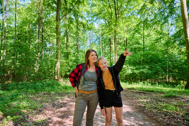 istock Mother and daughter standing in forest 1494383755