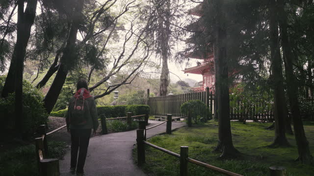 Woman Traveler with Backpack Exploring Japanese Garden in Golden Gate Park, San Francisco