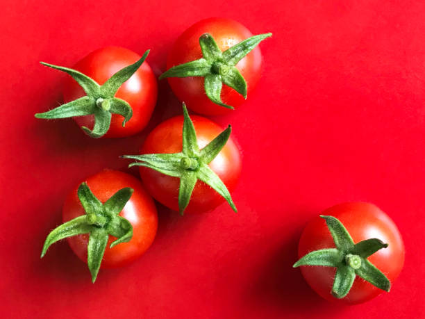 istock Five Ripe Cherry Tomato Summer Vegetables on Bright Red Background 1494386662