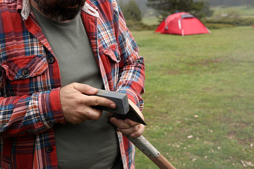 Man Checking Axe Sharp Edge