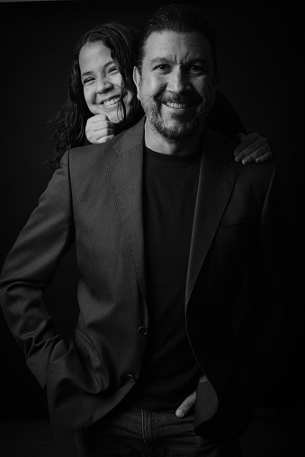 Black and white shot of just married young couple having fun while piggybacking in nature