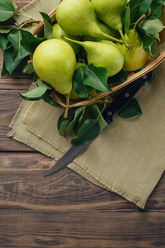 Pears. Fresh sweet organic pears with leaves in wooden box or basket on old dark gray background. Autumn harvest of fruits. Top view. Food background. Top view, flat lay. Copyspace. Banner.
