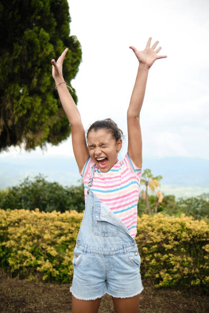 girl raising both arms up screaming