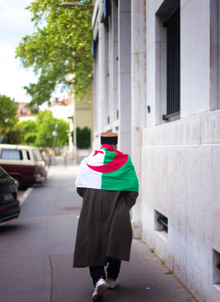 Lyon, France: A senior man wrapped in a Tunisian flag walks in the 3rd arrondissement.