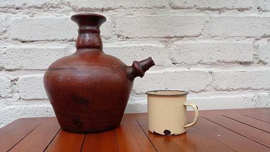 water jugs and enamel or aluminum mugs. retro concept. white wall background. copy space.