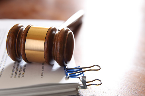 A gavel rests on top of a stack of legal documents that provide ample room for copy and text.